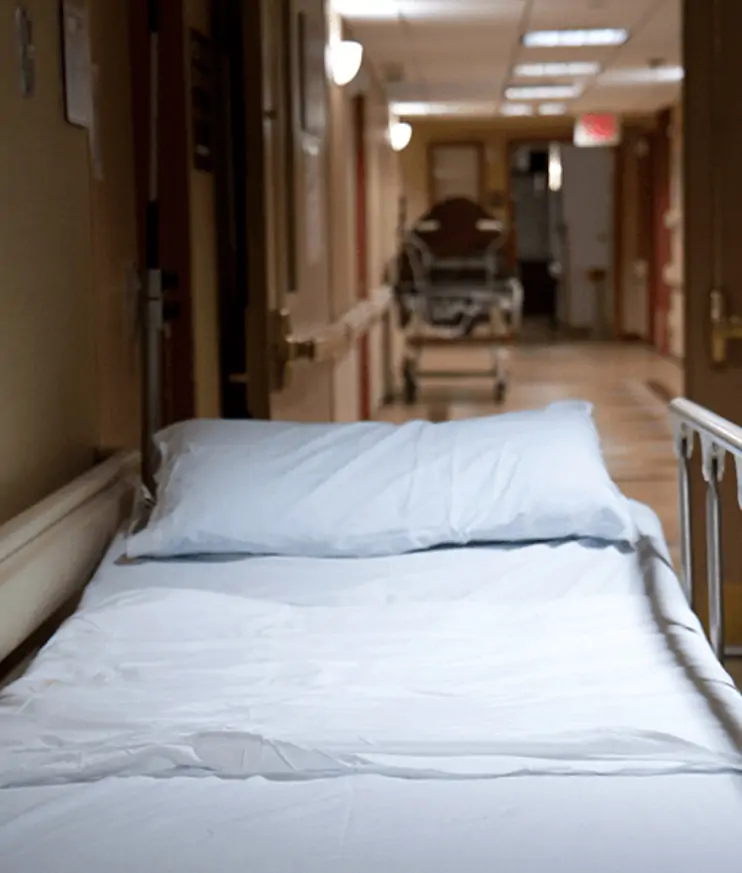 Empty hospital bed in a healthcare corridor
